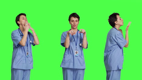 Flirty-cute-nurse-blowing-air-kisses-against-greenscreen-backdrop